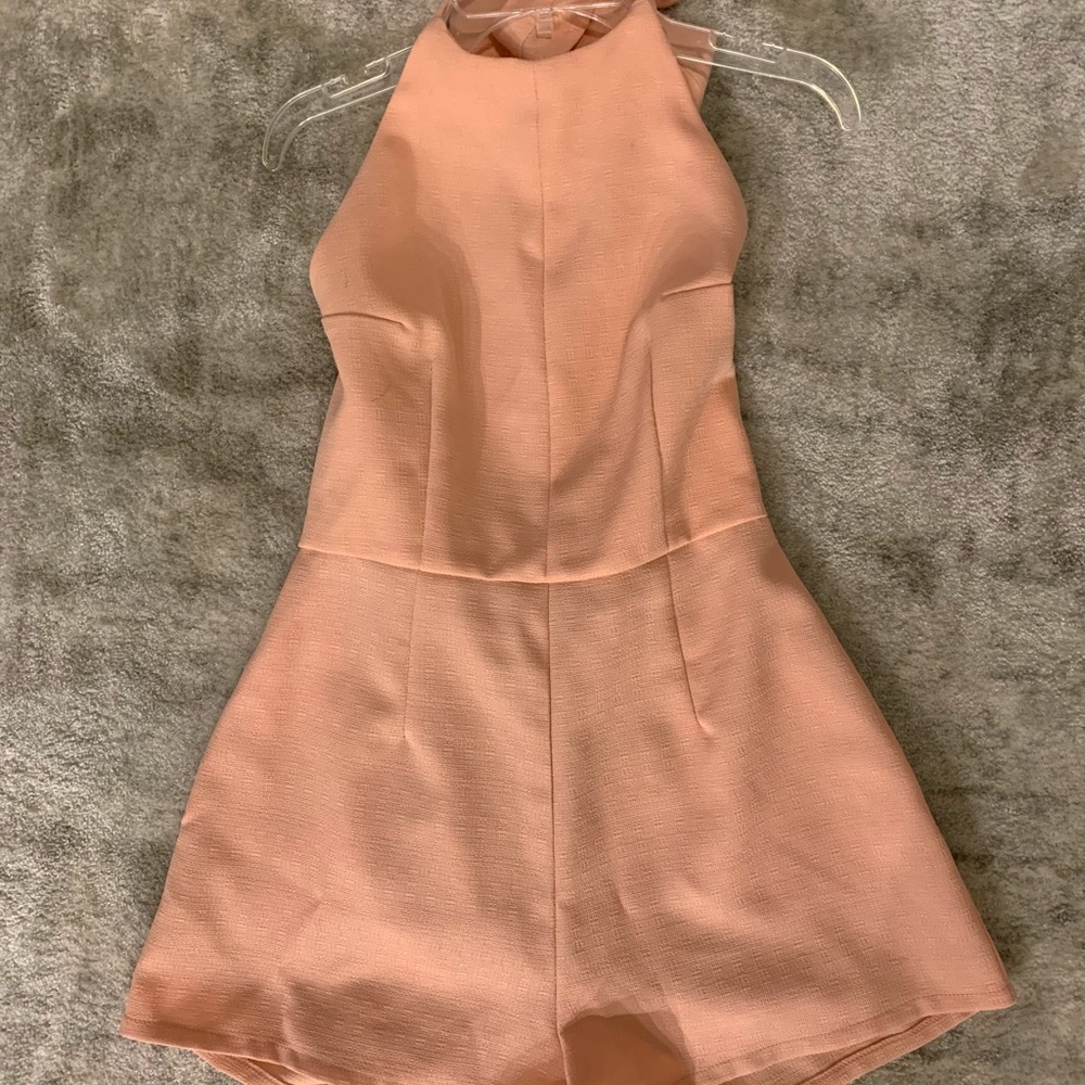 Peach colored sleeveless romper w/ open back